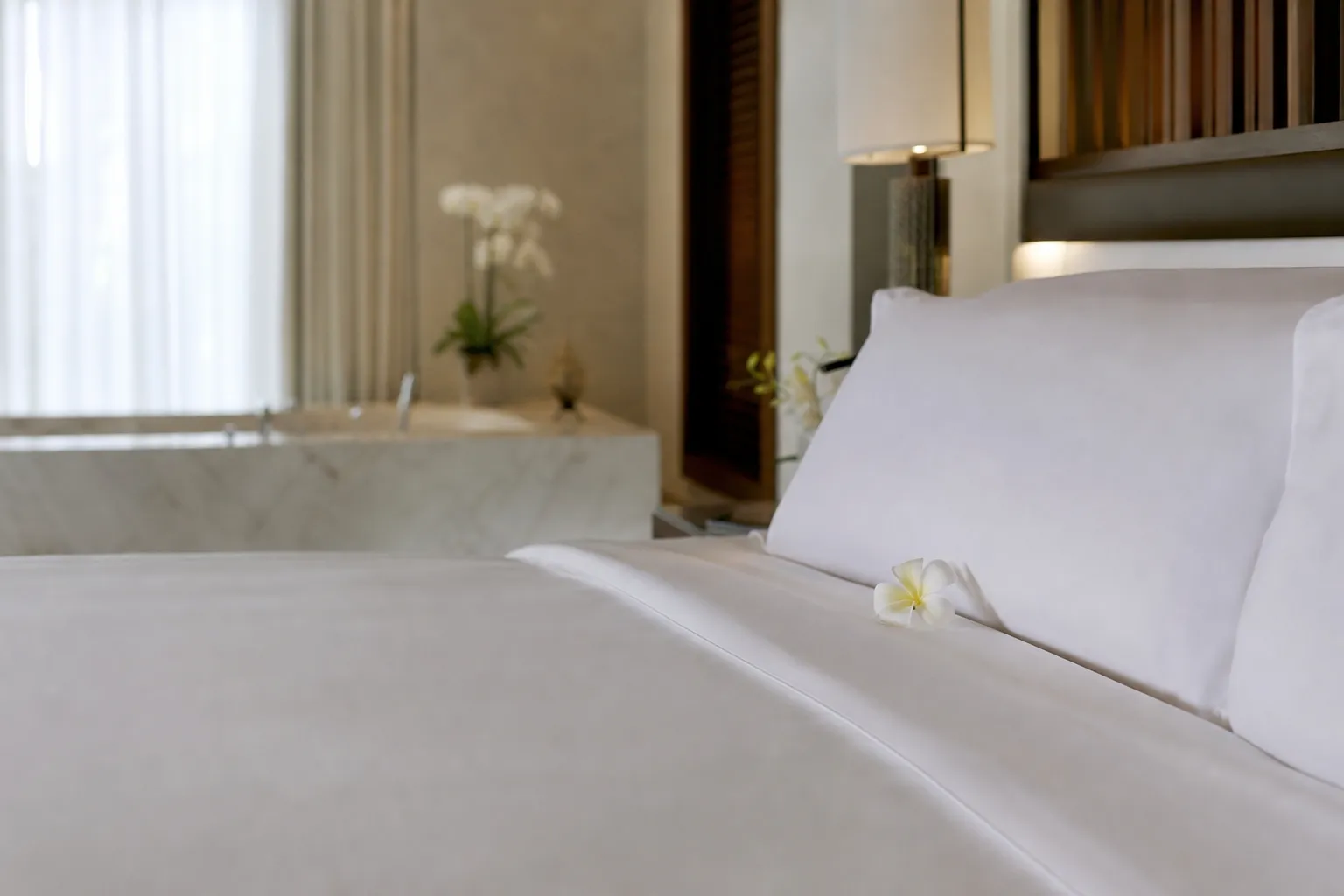 Lit impeccable avec drap blanc et fleur de frangipanier — Ménage blanchisserie Martinique